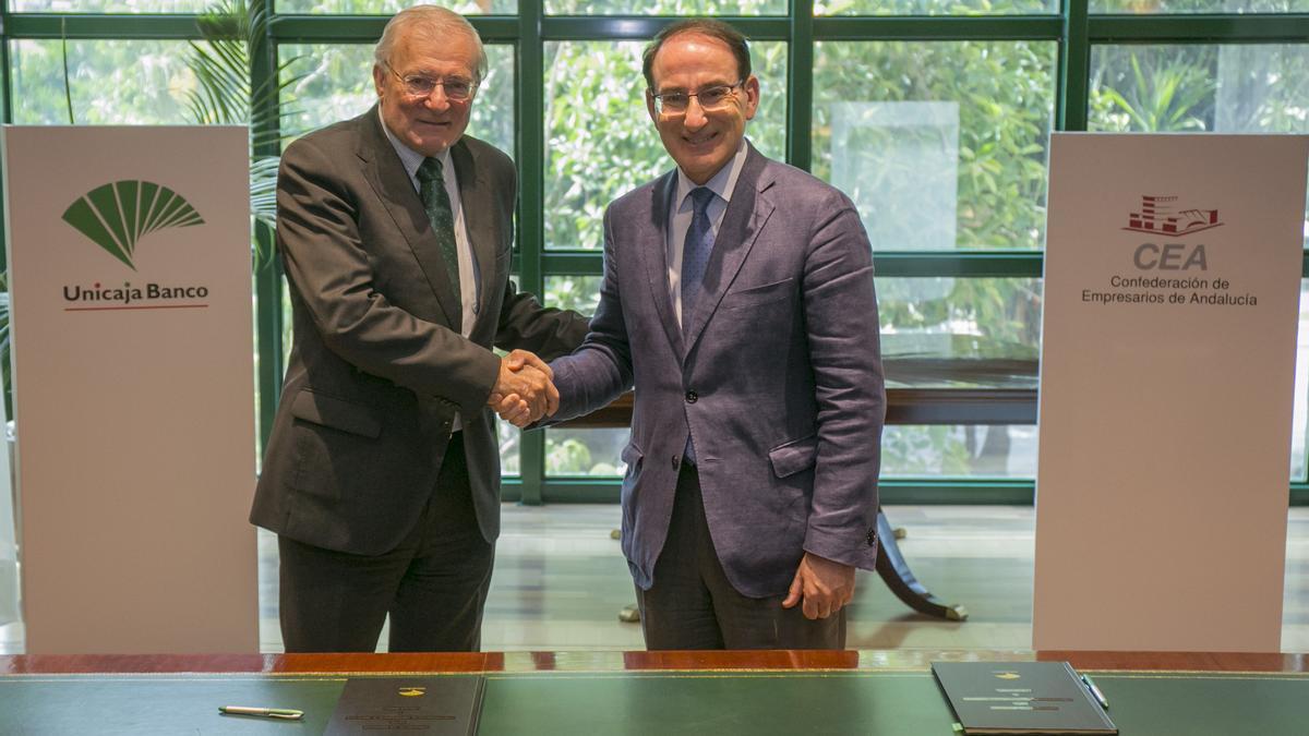 Firma del acuerdo entre los presidentes de Unicaja, Manuel Azuaga; y la CEA, Javier González de Lara.