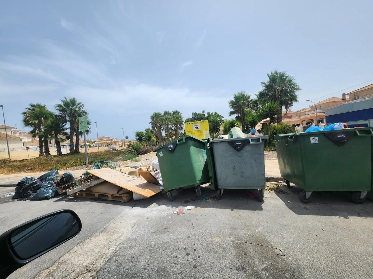 Así están los contenedores de basura de San Miguel de Salinas: hasta arriba de podas y enseres sin que Actúa los retire