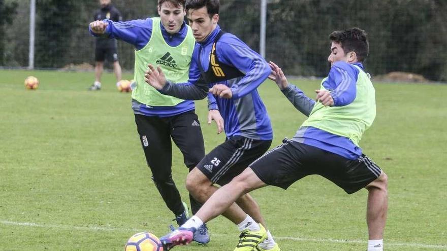 Borja Domínguez trata de salvar la entrada de Carlitos de Pena en presencia de Jon Erice, ayer, en el entrenamiento en El Requexón.