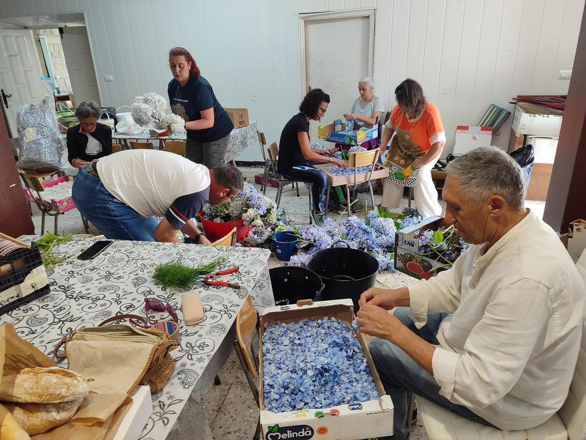 Alfombristas de Bueu y Castropol trabajando ayer en los materiales para una alfombra delante de la iglesia de Bueu.