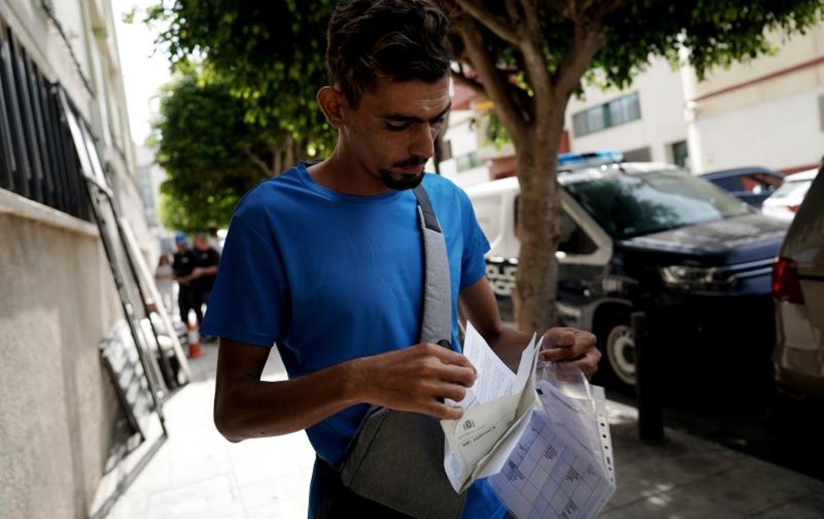 Abdel Raouf, argelino, nadó 7 kilómetros para llegar a la playa del Tarajal. Ahora tramita su residencia... o expulsión. En la imagen, muestra sus papeles cerca de la comisaría de Policia de Ceuta