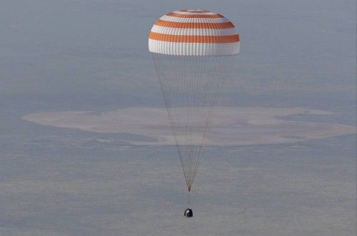 The Soyuz TMA-11M capsule with the International Space Station (ISS) crew members descends beneath a parachute just before landing in central Kazakhstan