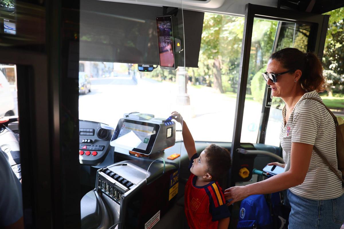 Lorena Gayol, vecina de la Manjoya, entrando a un autobús junto a su hijo.