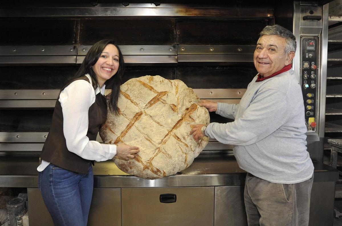 María junto a su padre, Paulino González, en el obrador de la panadería. | BERNABÉ/JAVIER LALÍN