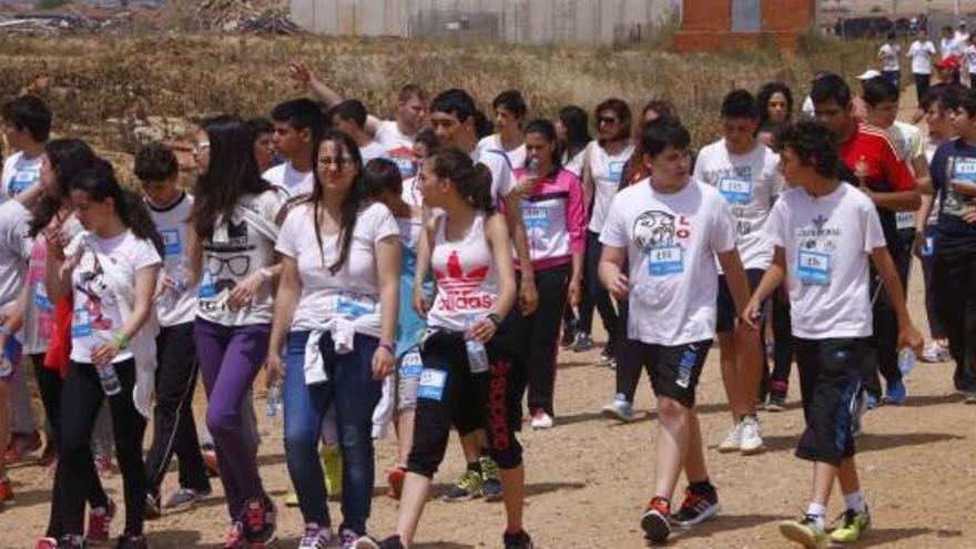 Los chicos y chicas avanzan por un camino rural a las afueras de la villa.