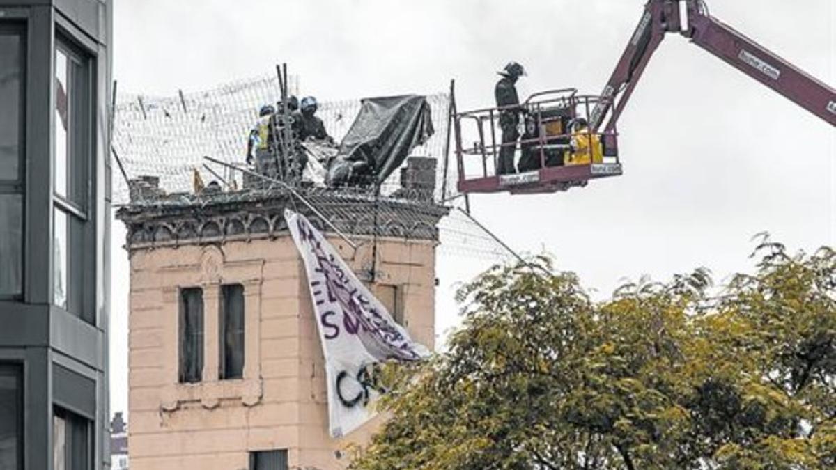 Varios mossos intentan desmantelar uno de los puntos de resistencia, ayer, en la azotea de Can Vies.