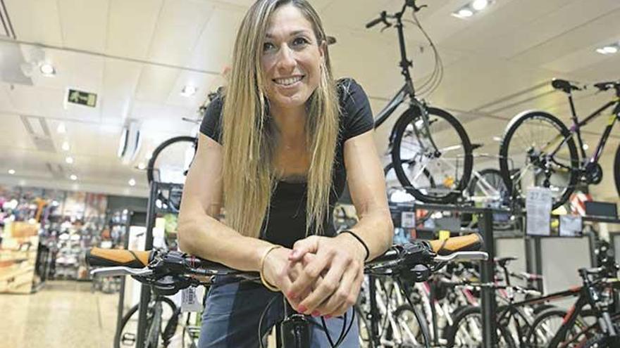 La ciclista mallorquina Mavi García, posa sonriente sobre una bicicleta, tras anunciar su fichaje por el equipo femenino Movistar.