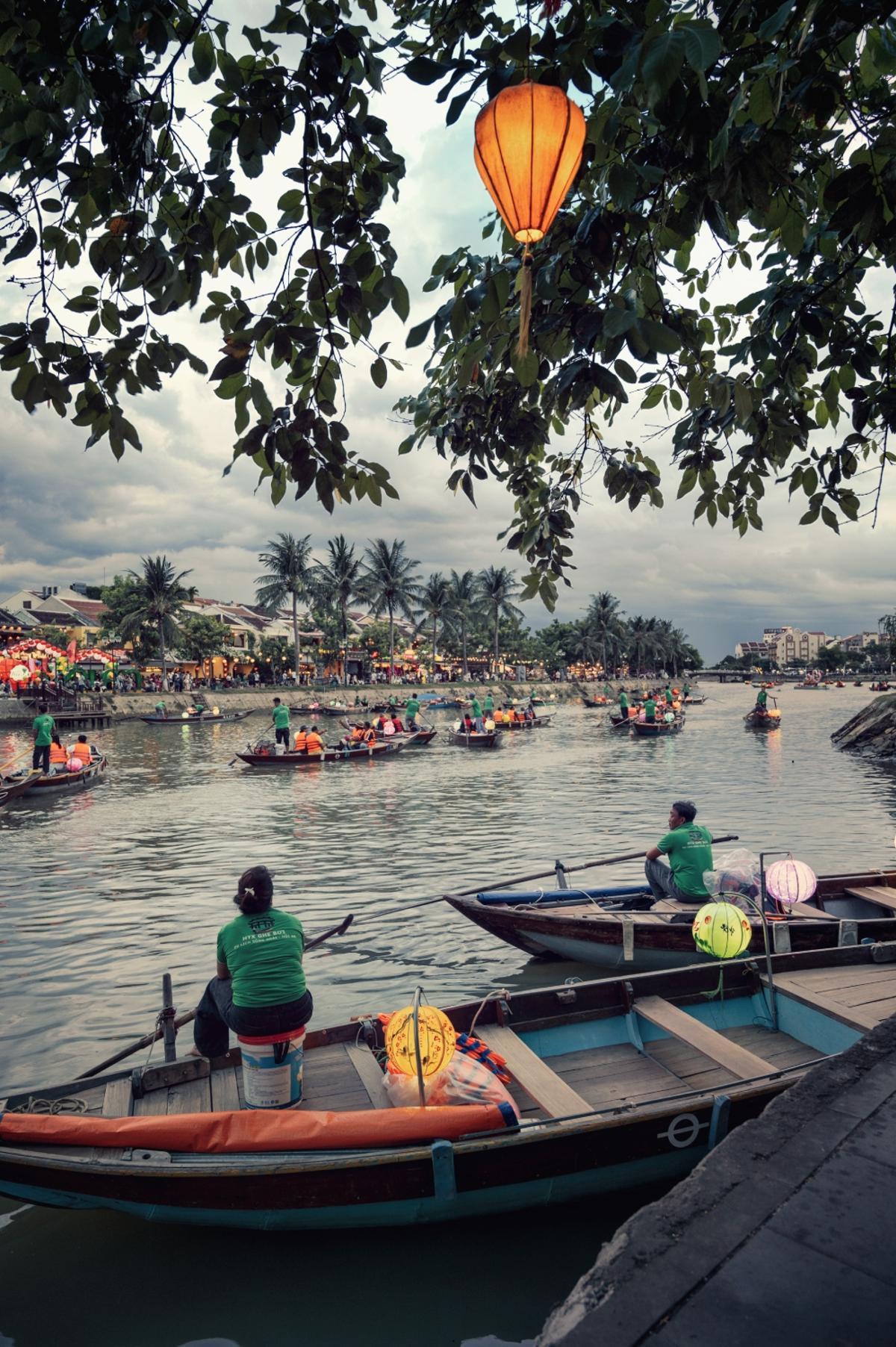 Barcas llenando de colorido el río en Hoi An al anochecer.