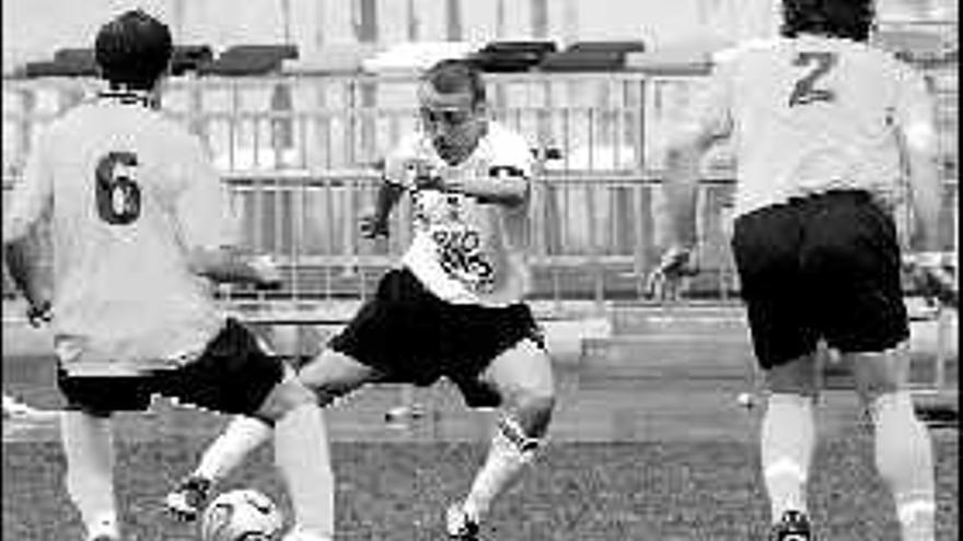 El caudalista Iván Parra controla el cuero ante dos futbolistas del Cudillero.