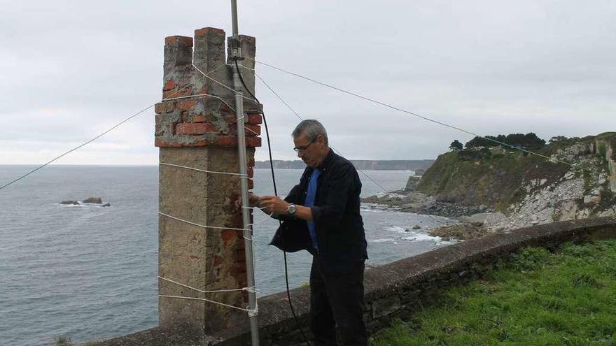 El secretario de la Unión de Radioaficionados de Avilés, Carlos Fernández, instalando una de las antenas en el faro de Luarca.