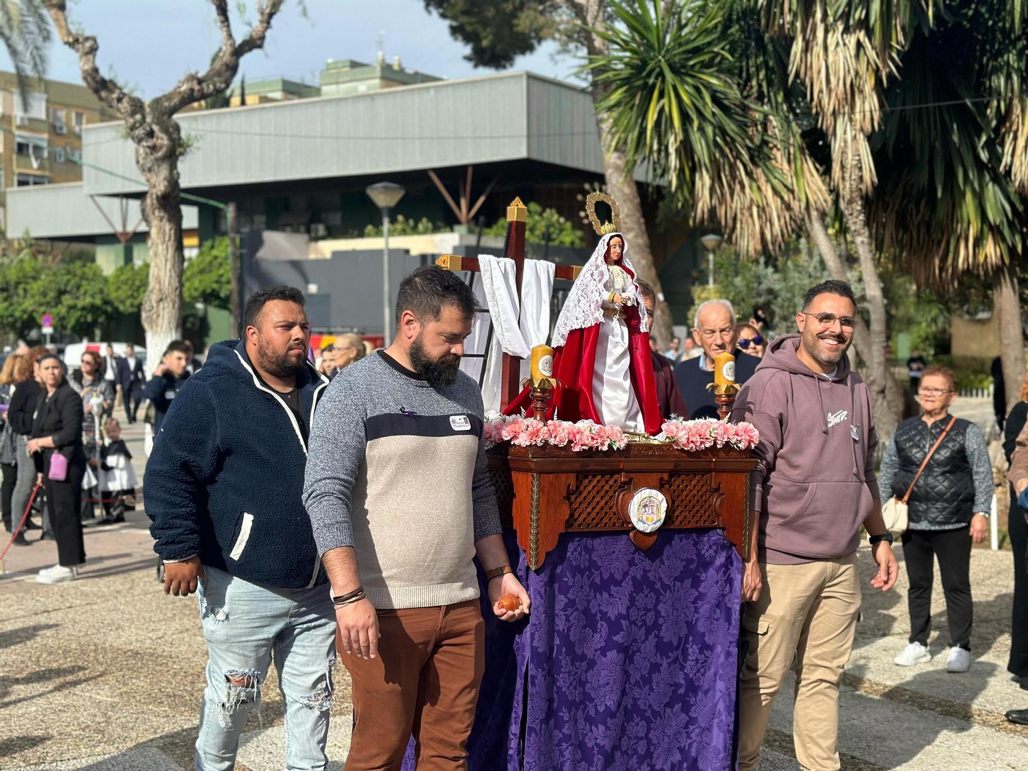 Padres del Colegio Adriano saludan a la Hermandad de Pino Montano junto a sus hijos, que van de costaleros de la Virgen del Pucherito.