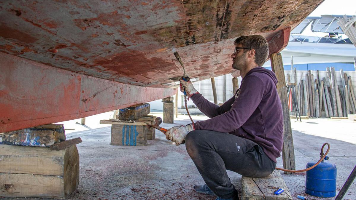 Trabajos de limpieza de un barco de madera en Es Botafoc Ibiza