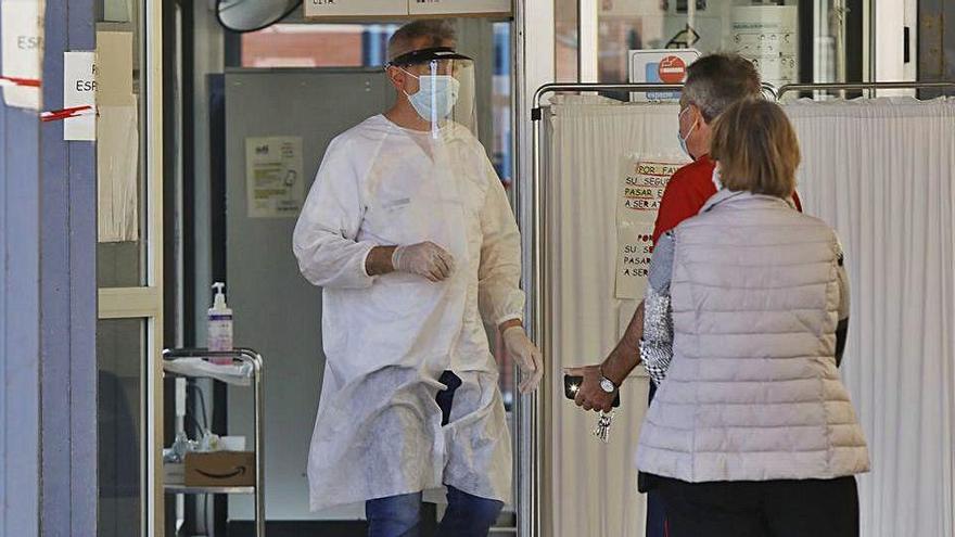 Un sanitario del Centro de Salud de Serrería de València, ayer, atiende a dos personas.