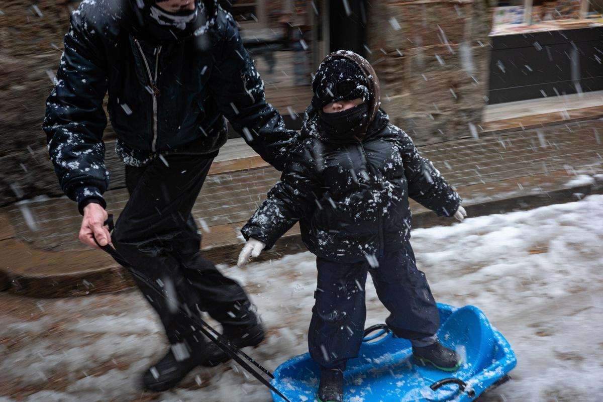 Un niño juega con un trineo en Solsona.