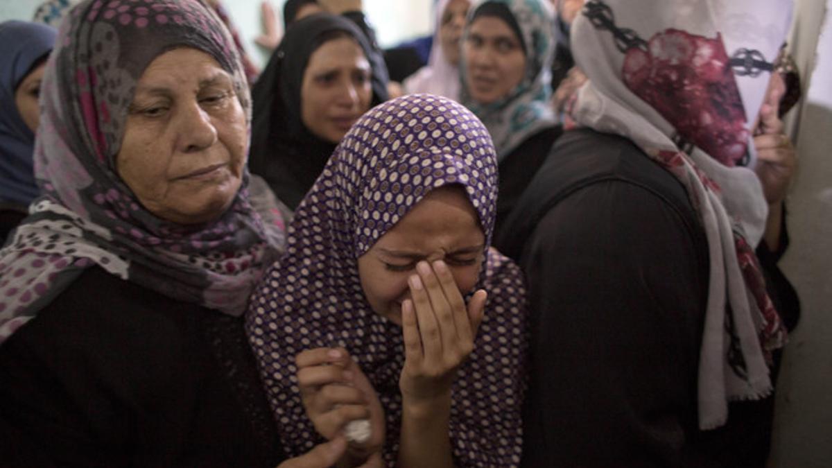 Mujeres palestinas lloran en el funeral de un niño muerto a consecuencia de un bombardeo de la aviación de Israel.