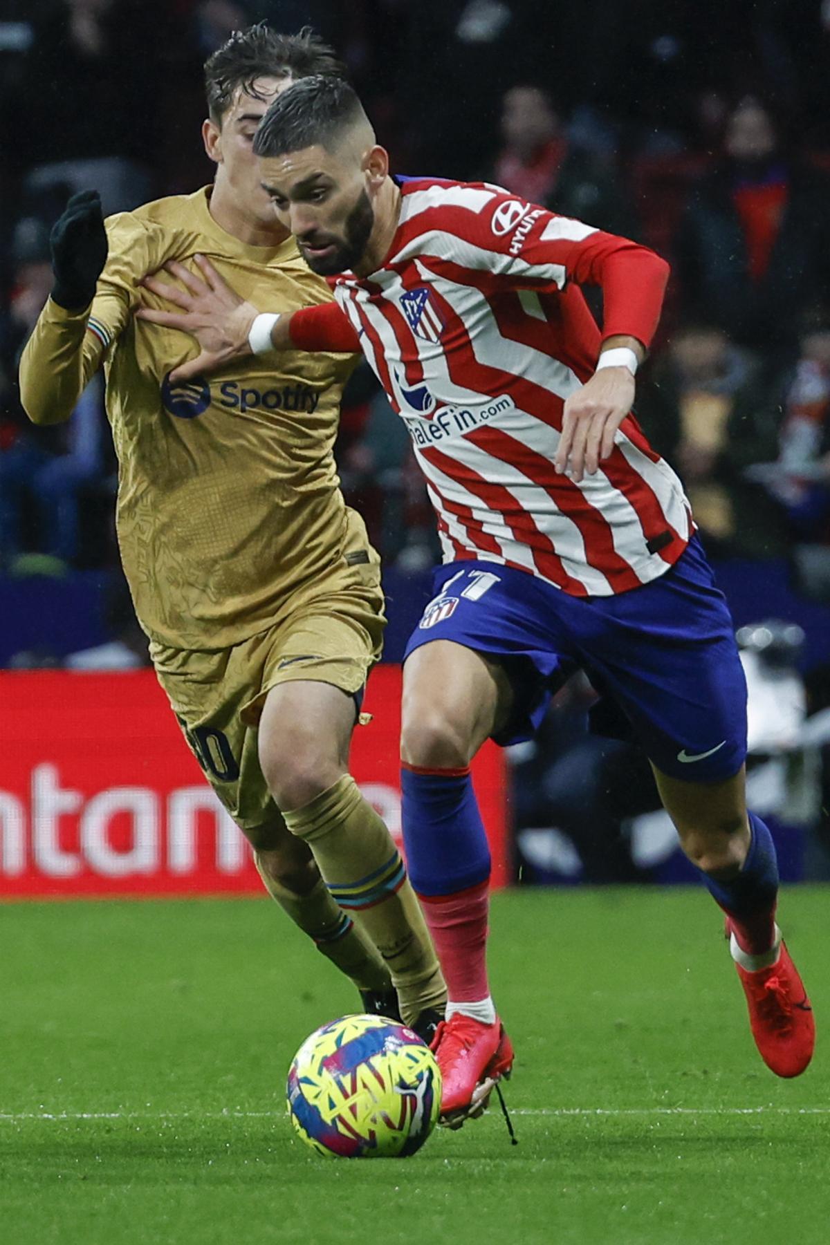 MADRID, 08/01/2023.- El centrocampista belga del Atlético de Madrid, Yannick Carrasco (d), conduce el balón ante el centrocampista del FC Barcelona, Gavi, durante el encuentro correspondiente a la jornada 16 de primera división que disputan hoy domingo en el estadio Metropolitano, en Madrid. EFE / J.J. Guillen.