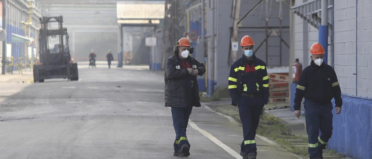 Tres trabajadores, dentro de la fábrica de Alu Ibérica.