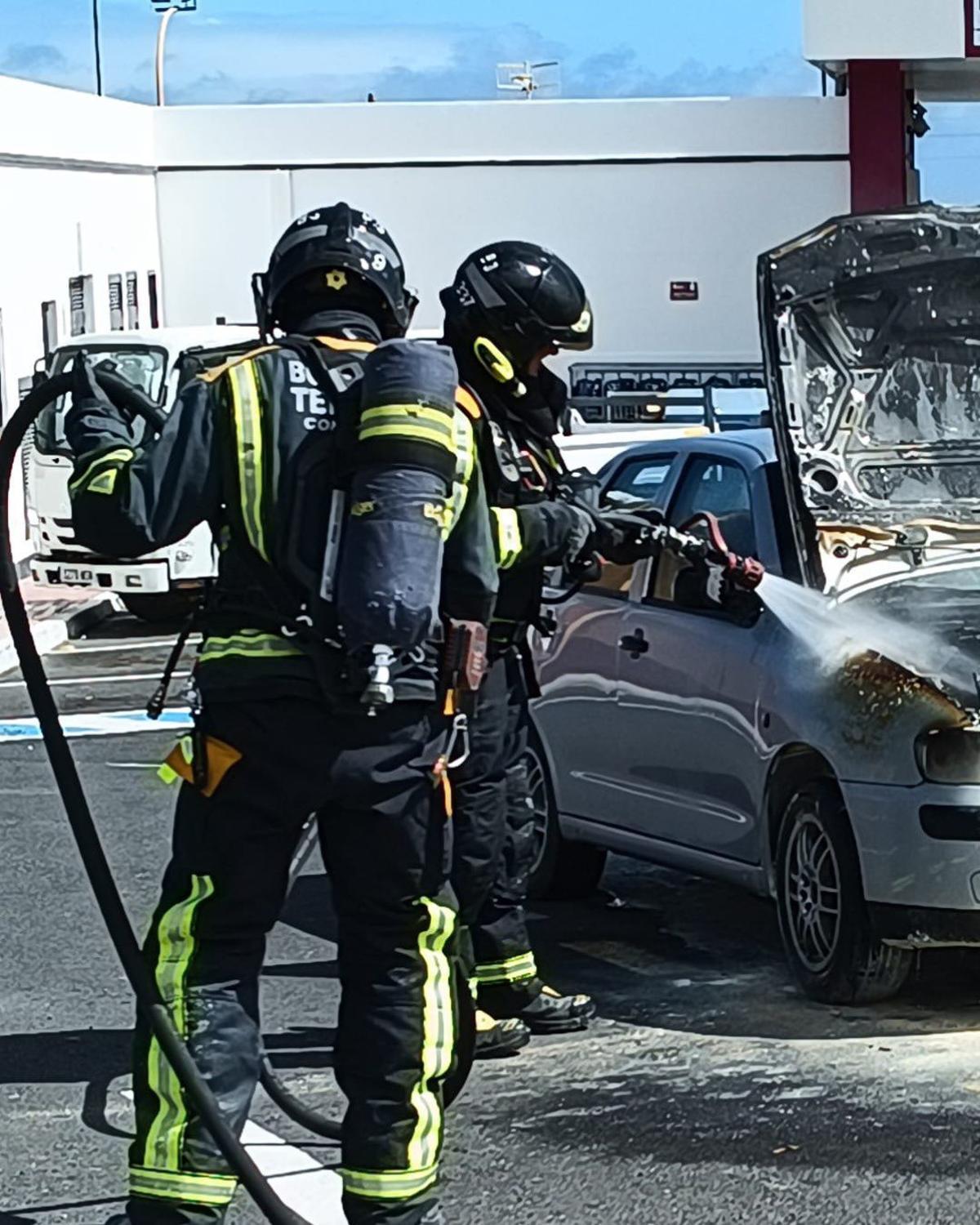Efectivos de Bomberos sofocando un fuego en un vehículo.