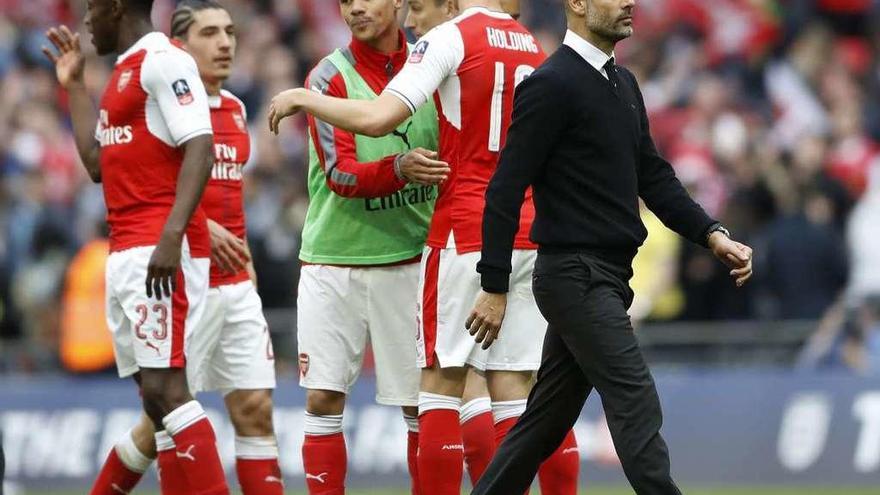 Guardiola pasa ante los jugadores del Arsenal al término del partido. // Carl Recine