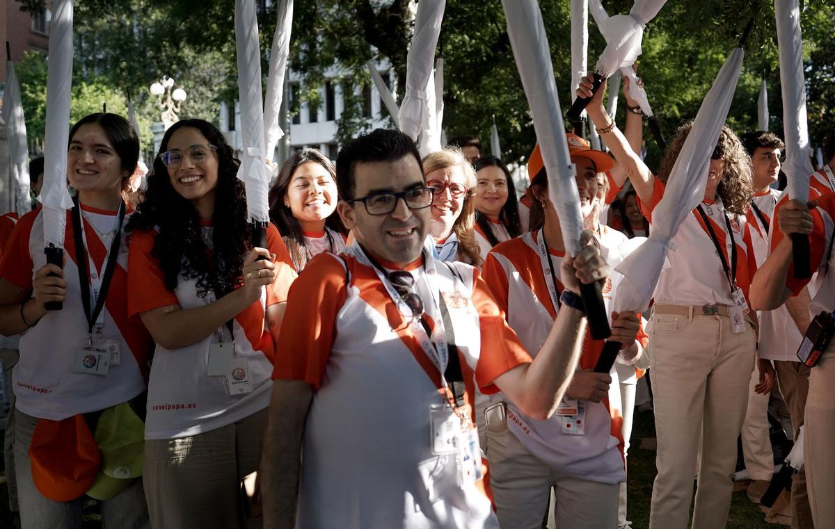Voluntarios con paraguas en la zona Cibeles donde se celebra la Santa MIsa.