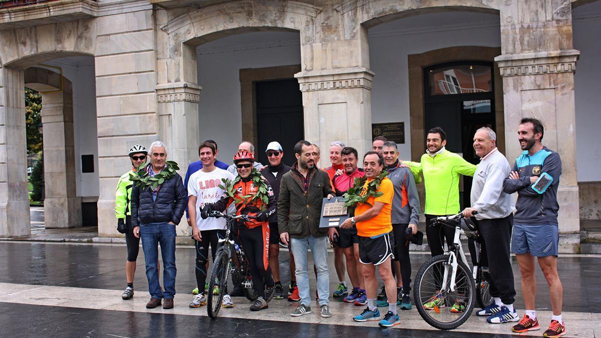 Juanjo Cima, de naranja en el centro, junto al alcalde de Siero, Ángel García, a su llegada a Pola de Siero en la última etapa