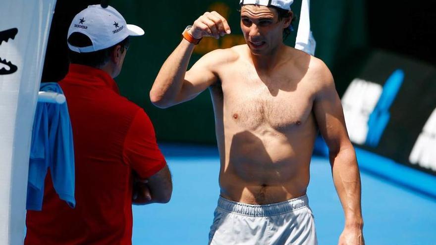 Rafa Nadal conversa con su tío Toni en el descanso del entrenamiento realizado ayer en Melbourne.