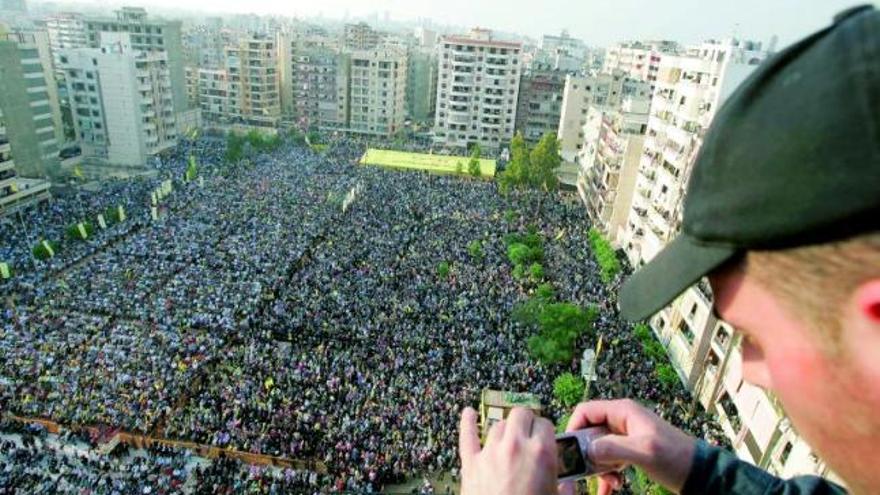 Un hombre hace una foto de la manifestación de Hezbolá en Beirut para conmemorar la retirada de Israel.