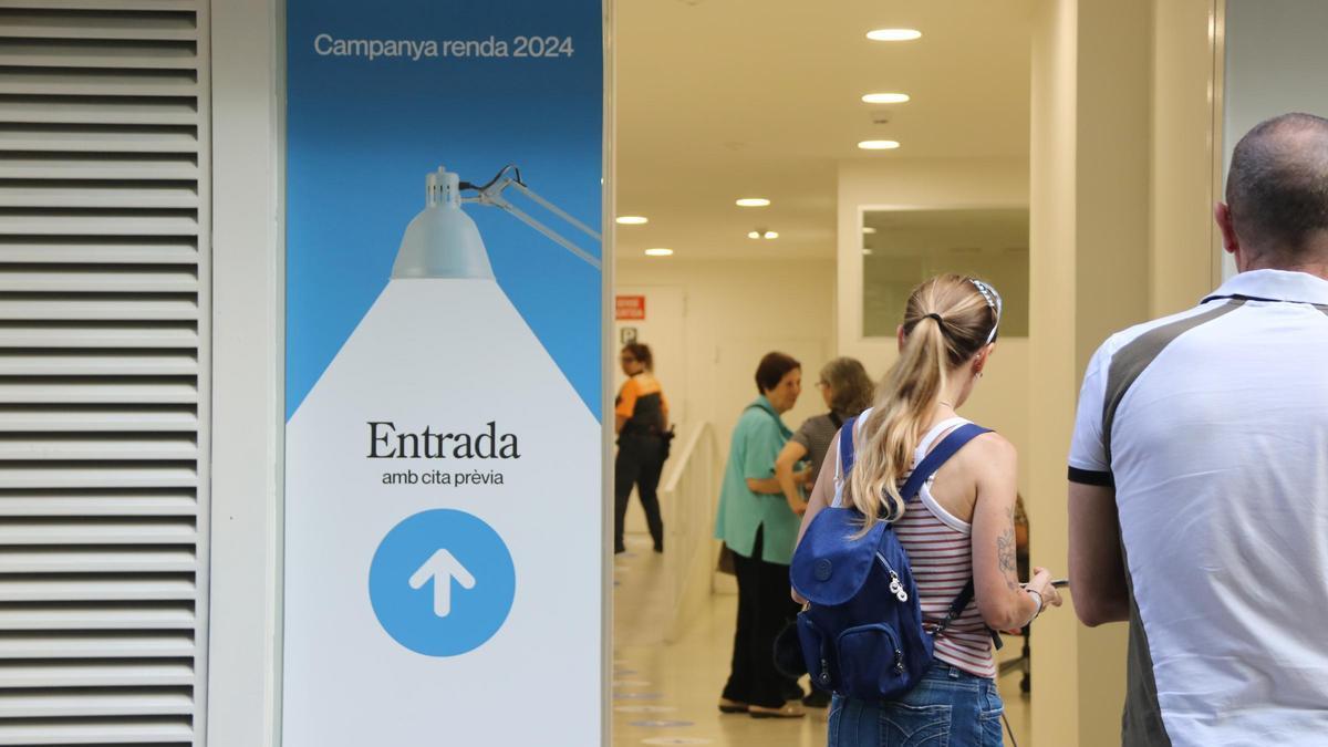 Persones fent cua a una oficina de l'Agència Tributària de Catalunya (ATC) per rebre atenció presencial per fer la declaració de la renda, en una imatge d'arxiu