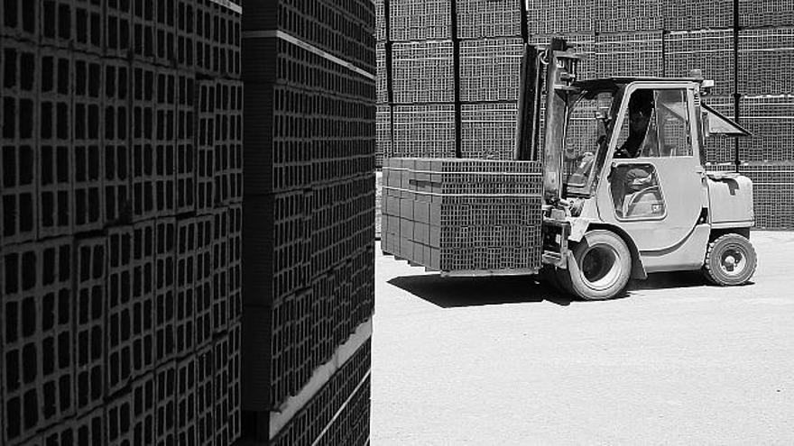 Un trabajador carga ladrillos para trasladarlos a una obra.