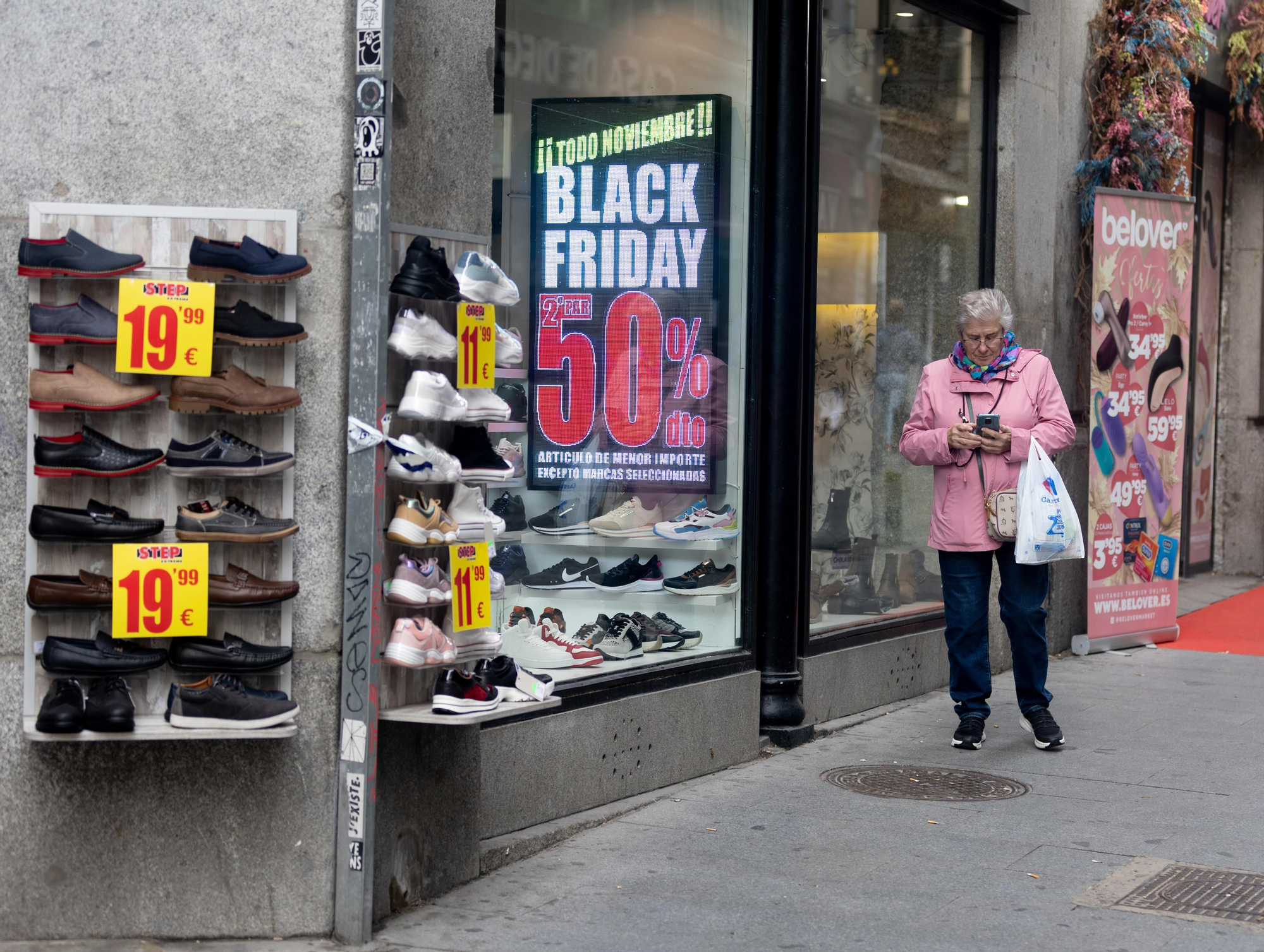 Una mujer pasa por delante de una tienda.