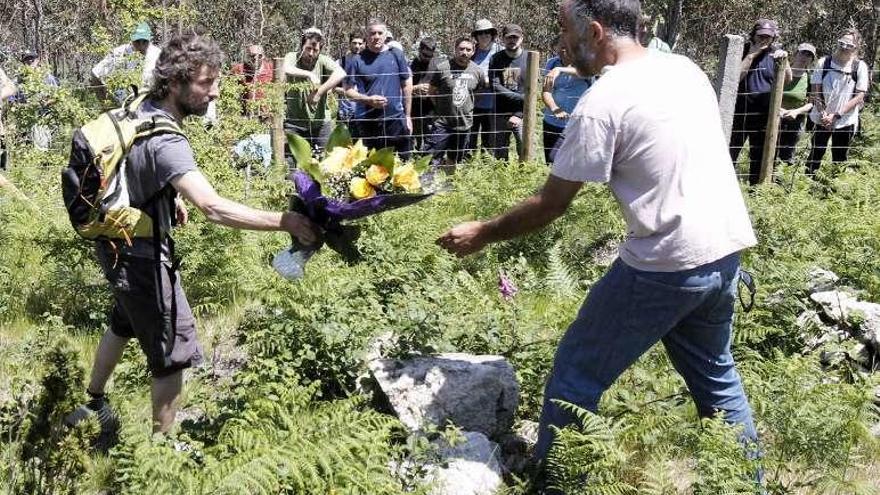 Unas personas colocan unas flores en la zona de la tragedia, ayer. // J. Lores