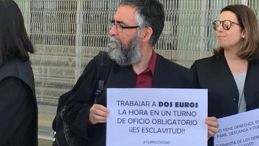 Dos profesionales muestran carteles en la protesta de mayo.