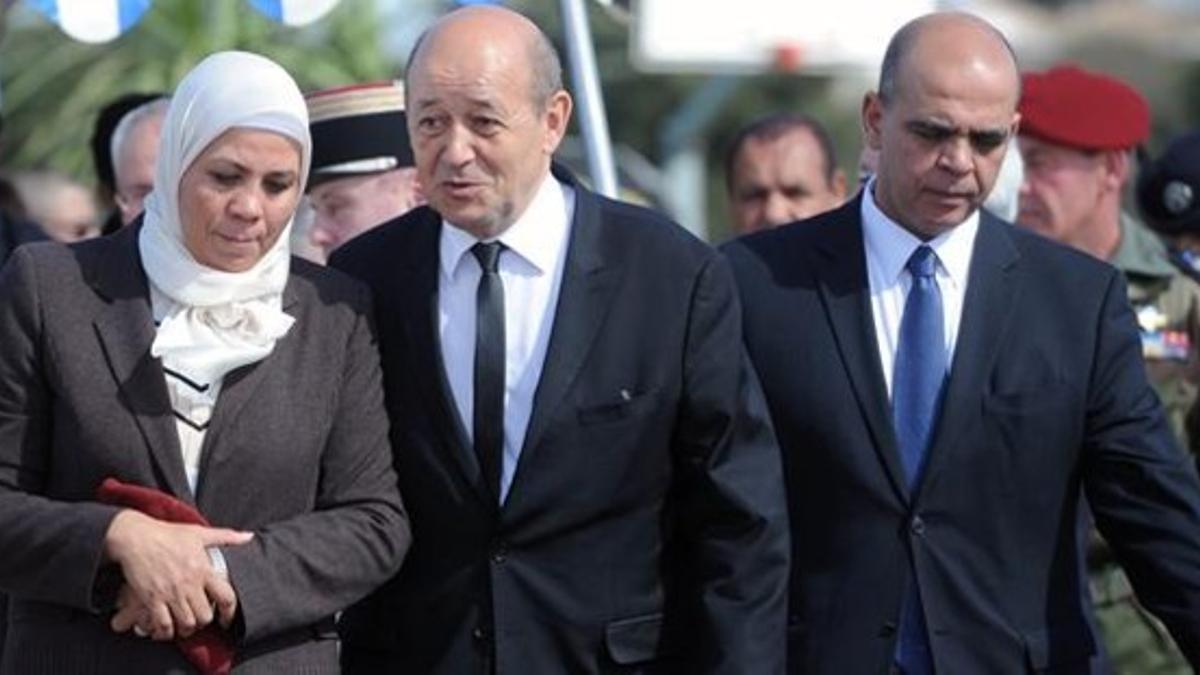 Le Drian (centro) habla con la madre de la primera víctima del islamista Merah, este lunes en Toulouse.