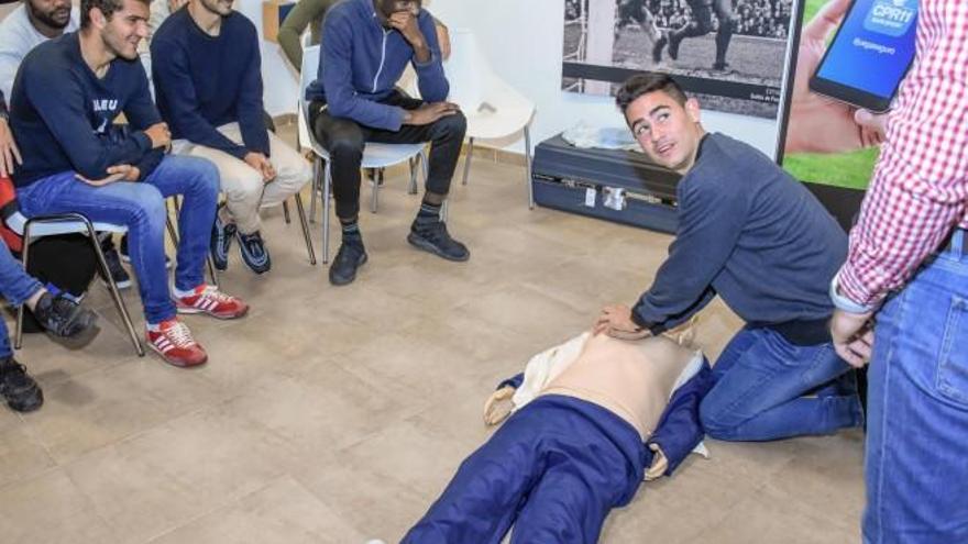 Los jugadores del Ilicitano realizando las prácticas de reanimación cardio pulmonar