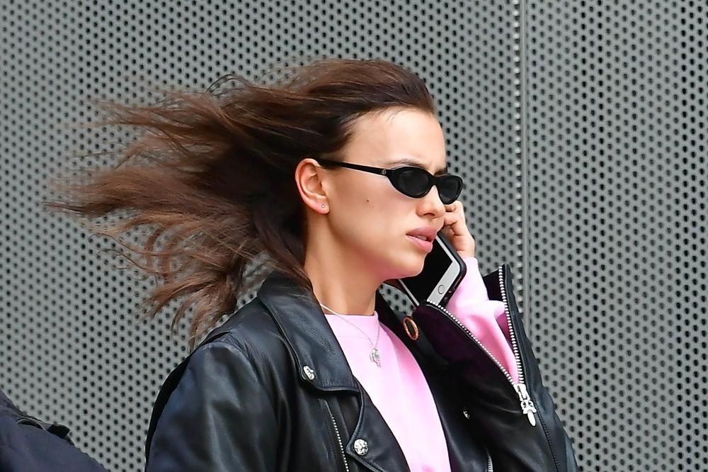 Primer plano de Irina Shayk hablando por teléfono mientras camina con prisa por Manhattan