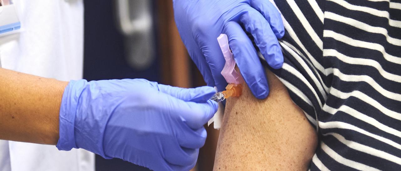 Un enfermero vacuna de la gripe a una mujer durante el inicio de la campaña de vacunación contra la gripe en Cantabria, en el centro de salud de Puertochico, a 10 de octubre de 2022, en Santander, Cantabria (España).