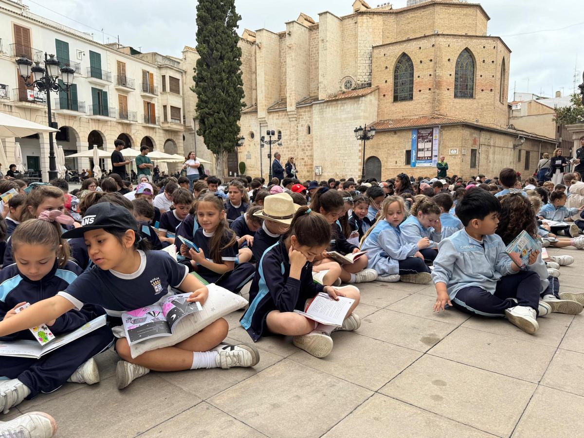 Decenas de alumnos participan en una lectura colectiva en la plaza de Gandia con motivo del Día del Libro.