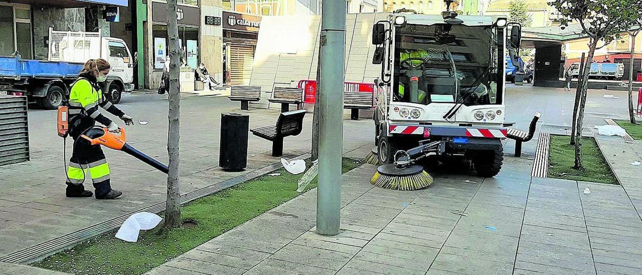 Operarios de la empresa Cespa, encargada del estado de las calles, durante las labores de limpieza en la plaza Major.