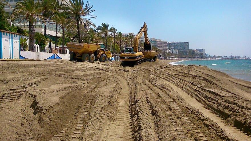 Maquinaria pesada repone arena en una de las playas de Marbella.