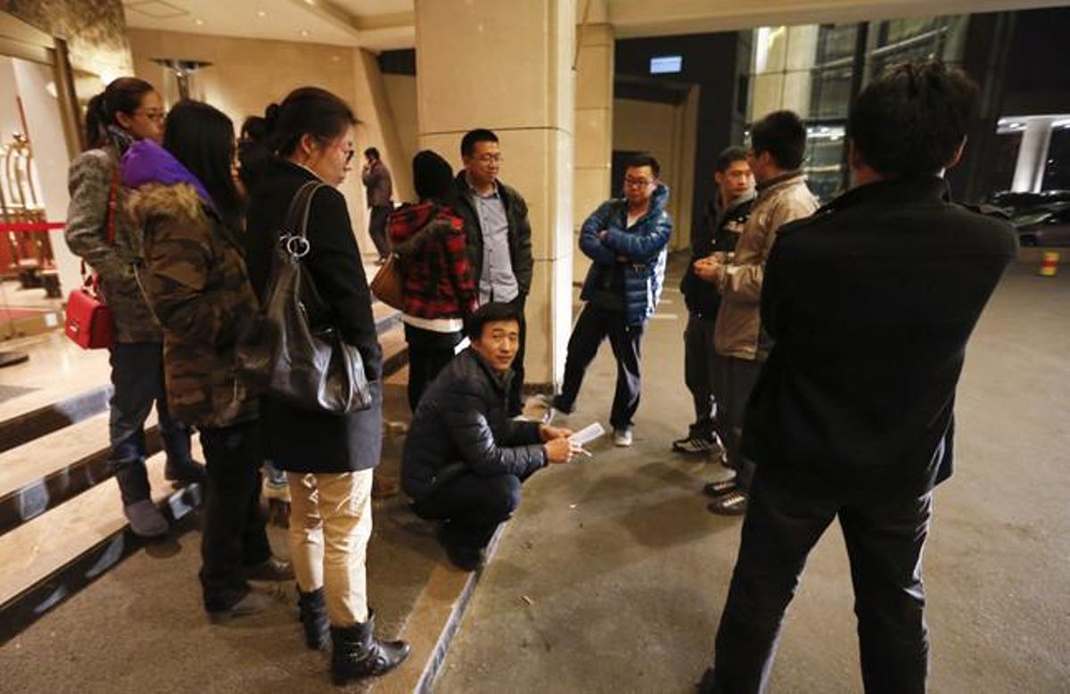 Familiars de passatgers xinesos del vol de Malaysia Airlines esperen notícies a l’hotel de Pequín on estan concentrats, aquest diumenge.