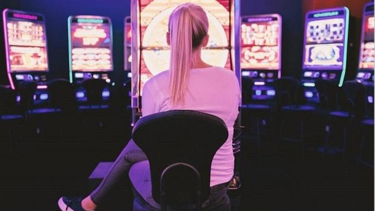 Una mujer en máquina de juegos de azar.