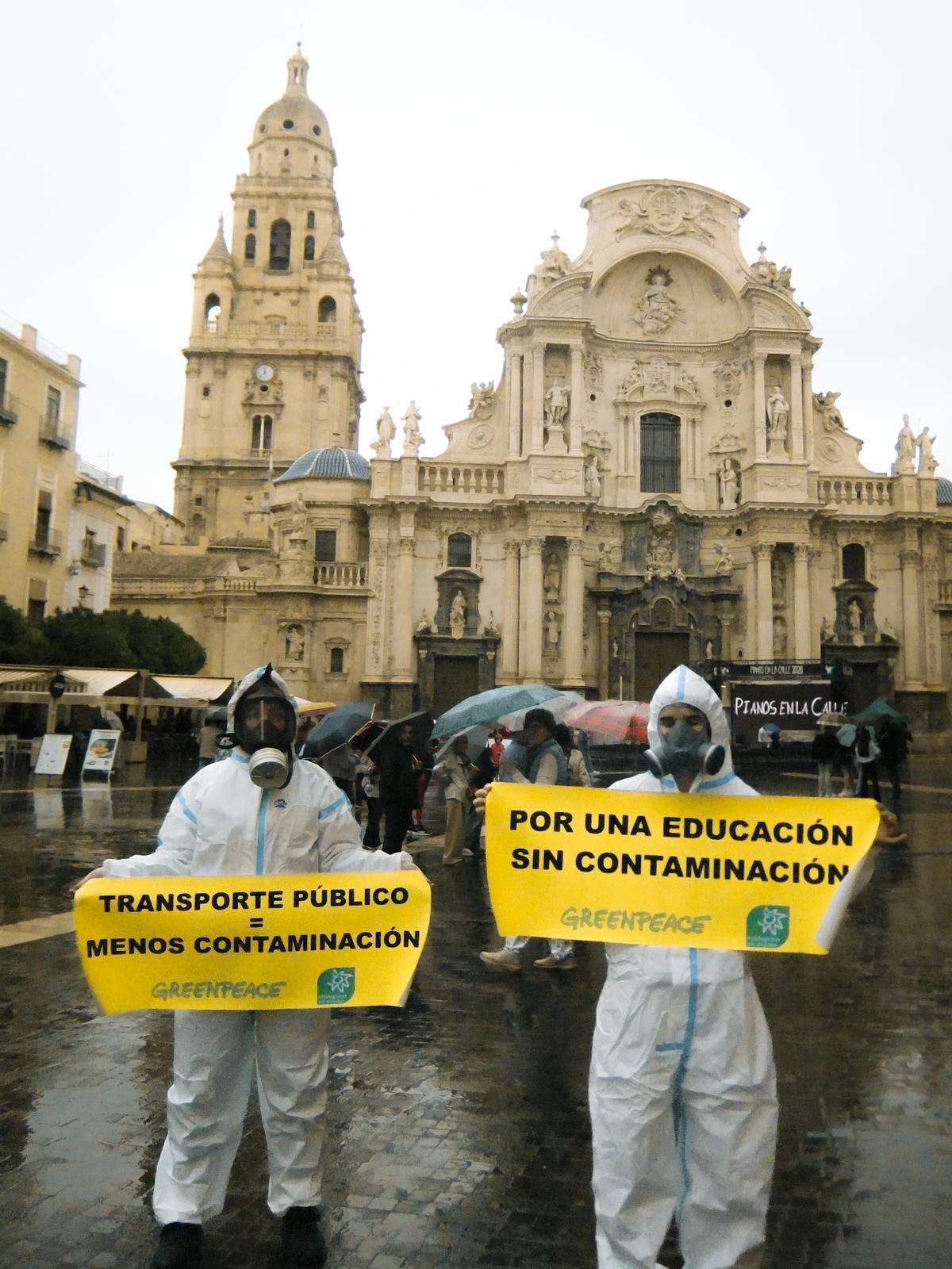 Voluntarios de Greenpeace y Ecologistas en Acción, con trajes de seguridad y mascarillas con filtros, en la plaza de la Catedral