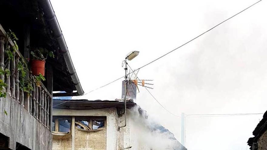 Labores de extinción en la casa incendiada en Villayón.