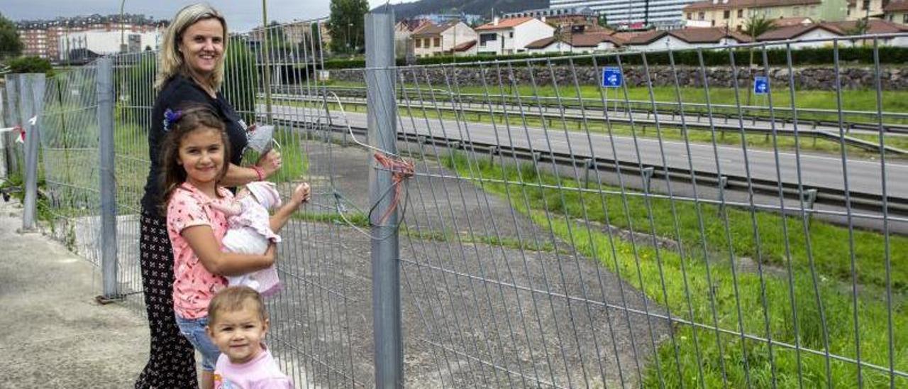 Isabel Pérez junto a sus hijas Claudia y Elena –la más pequeña–, ayer junto a la valla que separa Guillén Lafuerza del bulevar de Santullano. | Nazaret Quintas