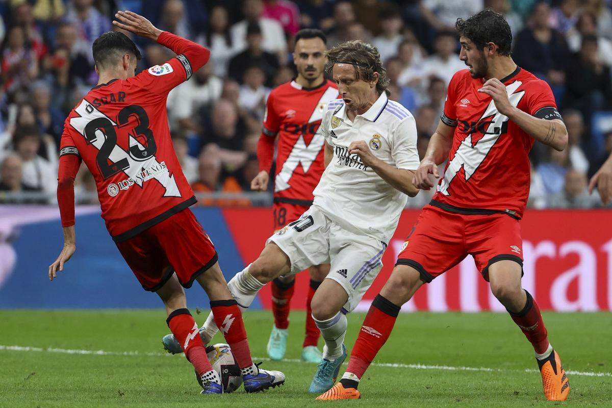 MADRID, 24/05/2023.- El centrocampista croata del Real Madrid, Luka Modric (c), disputa el balón ante los jugadores del Rayo Vallecano durante el encuentro correspondiente a la jornada 36 de primera división que disputan hoy miércoles en el estadio Santiago Bernabéu, en Madrid. EFE / Kiko Huesca.