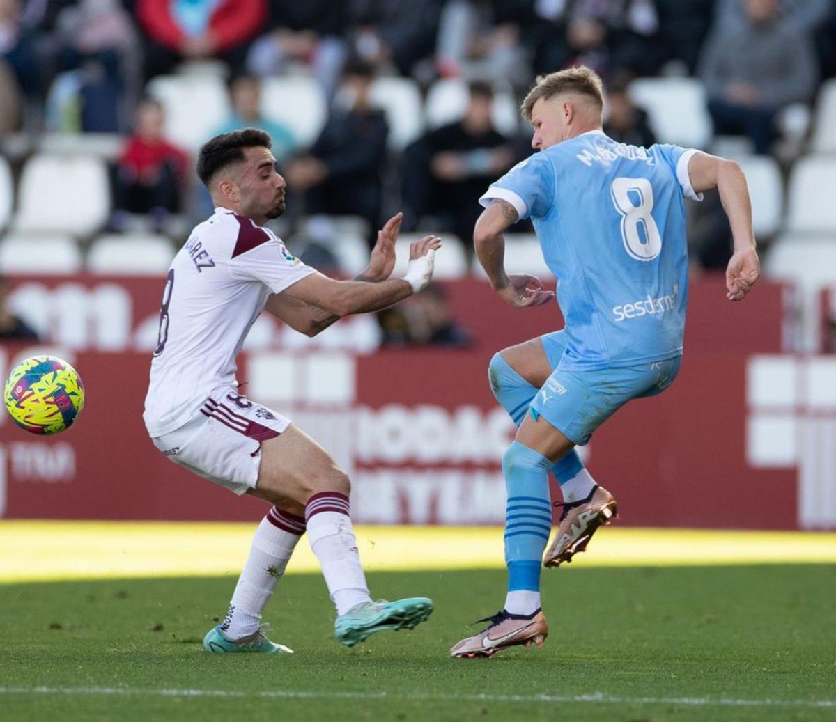 Mati Bogousz pasa el balón y trata de evitar el choque. | UD IBIZA