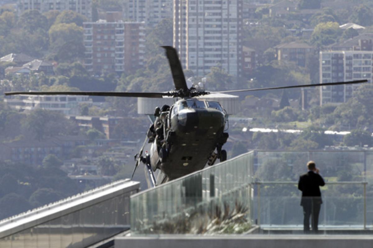 Un home de negocis observa un helicòpterBlackhawkque apareix entre els edificis durant unes maniobres antiterrorisme de l’exèrcit australià.
