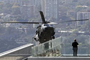 Un home de negocis observa un helicòpterBlackhawkque apareix entre els edificis durant unes maniobres antiterrorisme de l’exèrcit australià.