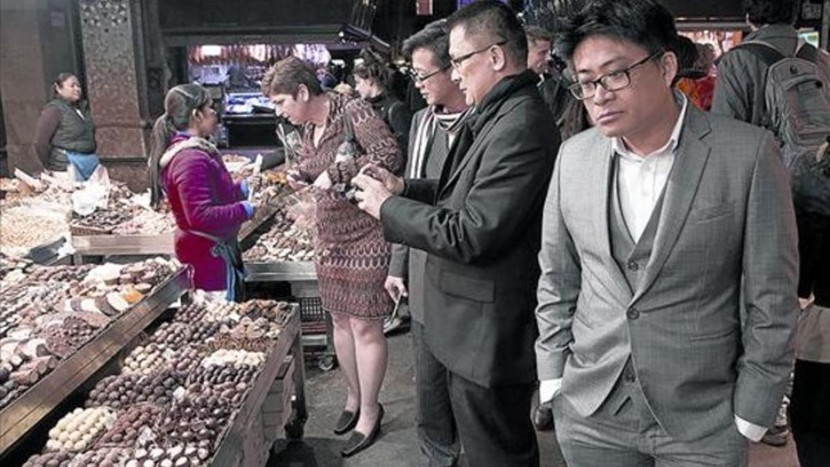 Participantes en el congreso de telefonía móvil visitan y fotografían la Boqueria, el pasado 3 de marzo.