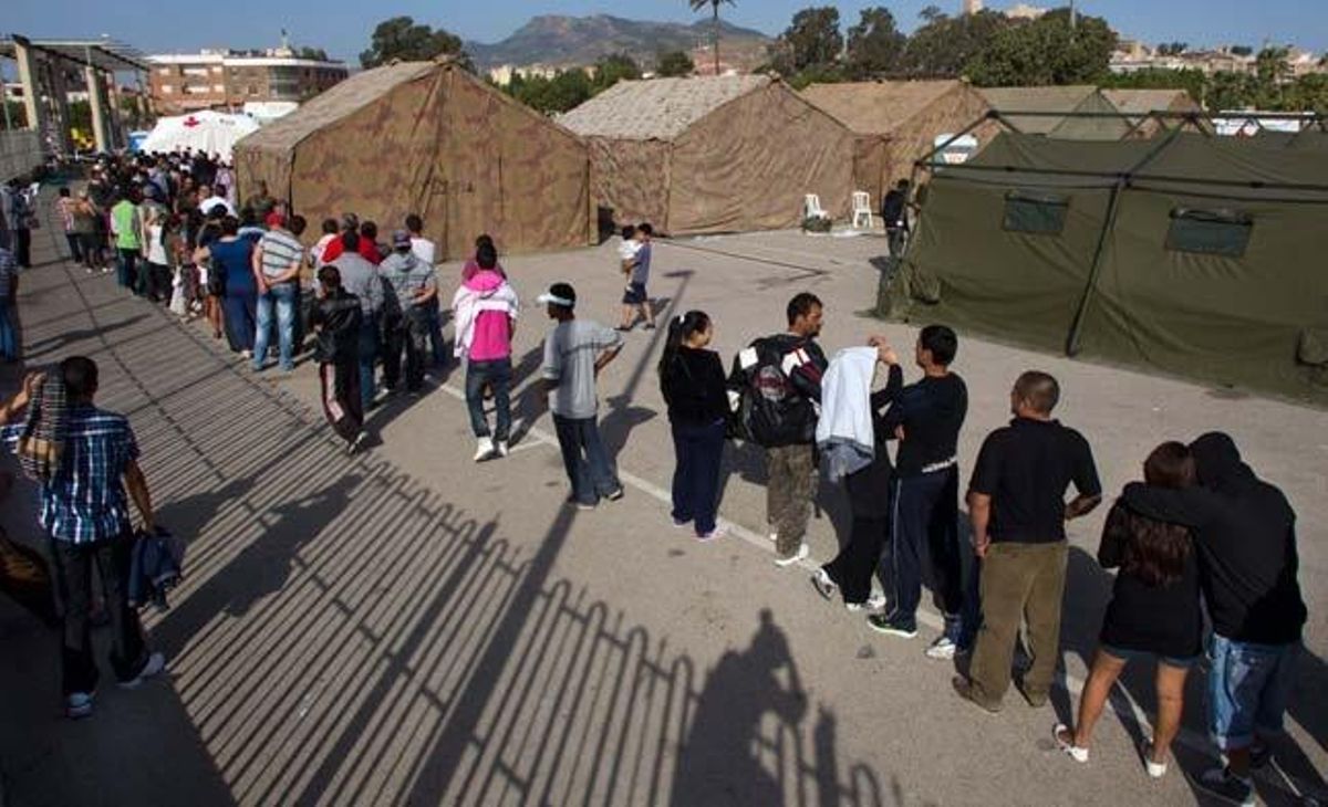 Centenars de ciutadans fan cua perquè tècnics de l’Ajuntament de Llorca, de la Creu Roja i de Protecció Civil comprovin les dades i la situació de cada un dels 2.750 acollits en un dels tres campaments instal·lats després dels terratrèmols.